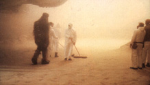 Crew members sweep up the sand in preparation for filming.